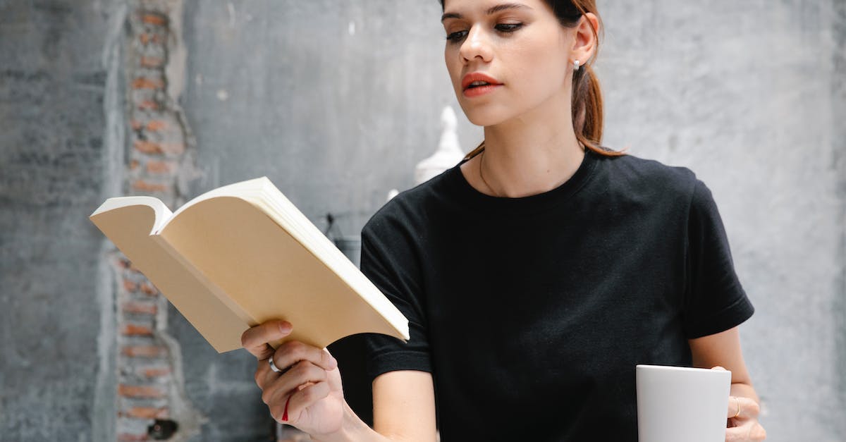 Why doesn't spell damage affect all cards? - Crop student with hot drink reading book against cement wall