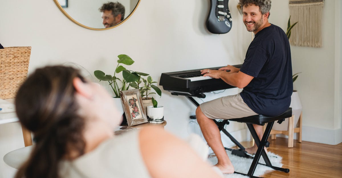 Why doesn't the music in Minecraft play all the time? - Loving adult male with beard and curly gray hair at wife while playing piano in cozy living room