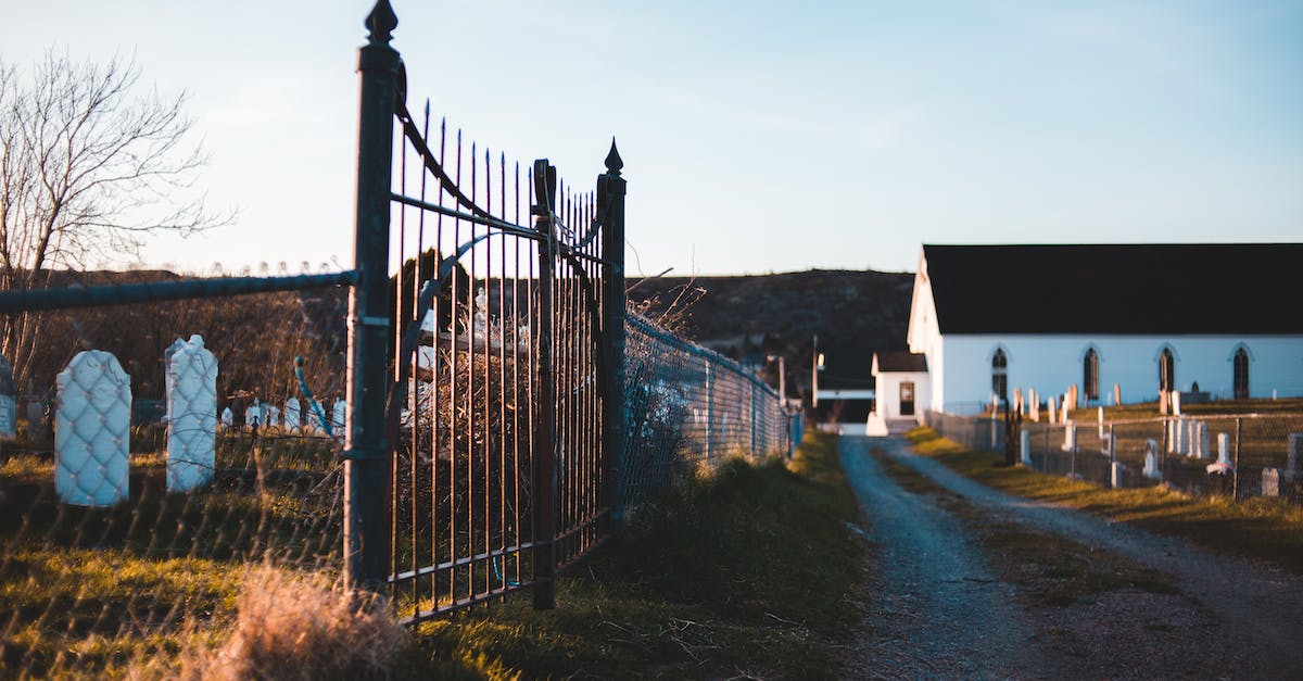 Why is Cybil with Harry in the graveyard after you beat Silent Hill? - Metal gate near walkway and aged building in cemetery
