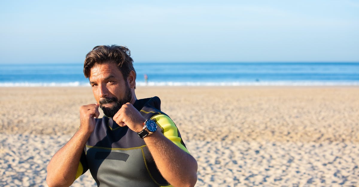 Why is Enderman not attacking while in water? - Concentrated male looking at camera holding clenched fists while shadow boxing on sandy beach