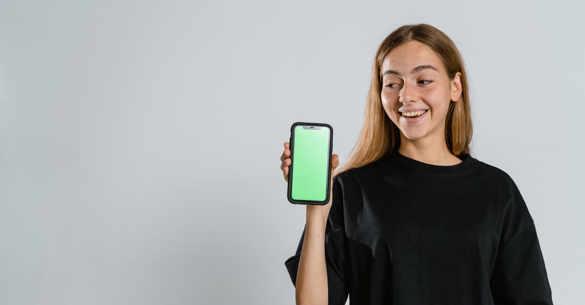 Why is Kaine glowing with a green aura? - Woman in Black Crew Neck T-shirt Holding Blue and White Iphone Case