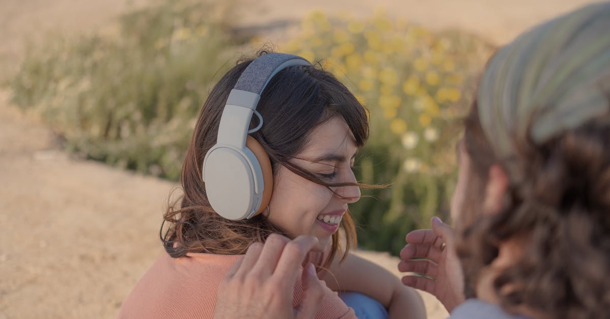 Why is my music becoming corrupted on my PS Vita? - Woman in Pink Knit Sweater Wearing White Headphones Why is my music becoming corrupted on my PS Vita? - Woman in Pink Knit Sweater Wearing White Headphones