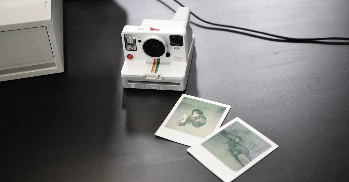 Why is my Wii U tablet home button flashing blue? - From above of contemporary photo camera with striped ornament near photos of woman on desk