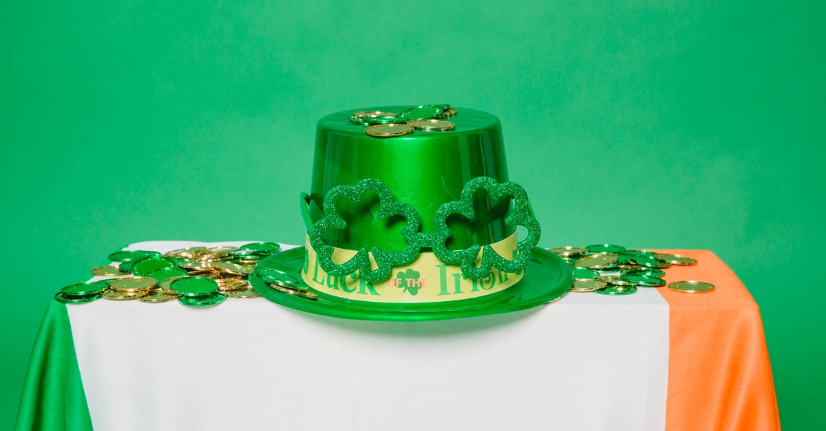 Why is that gold coin glowing green? - Green hat and coins on table with Irish flag Why is that gold coin glowing green? - Green hat and coins on table with Irish flag
