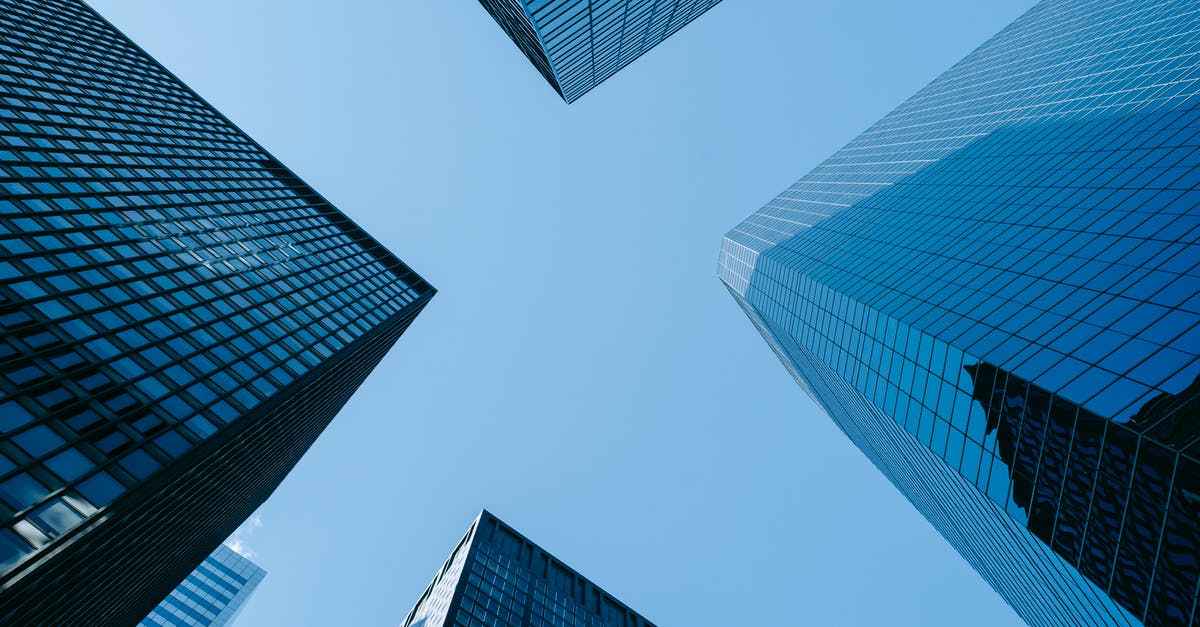 Why isn't Downtown Cab Company making any money? - Low angle of high business towers with glass mirrored windows located in megalopolis downtown against blue sky