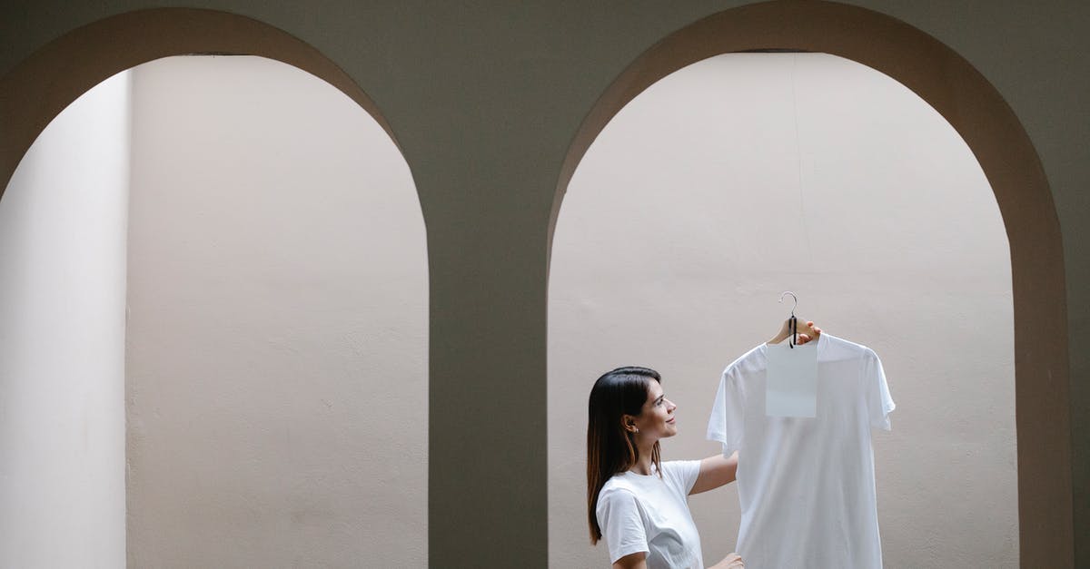 Why somethings don't show in friendly battles? - Stylish woman demonstrating t shirt on hanger near arched doorway