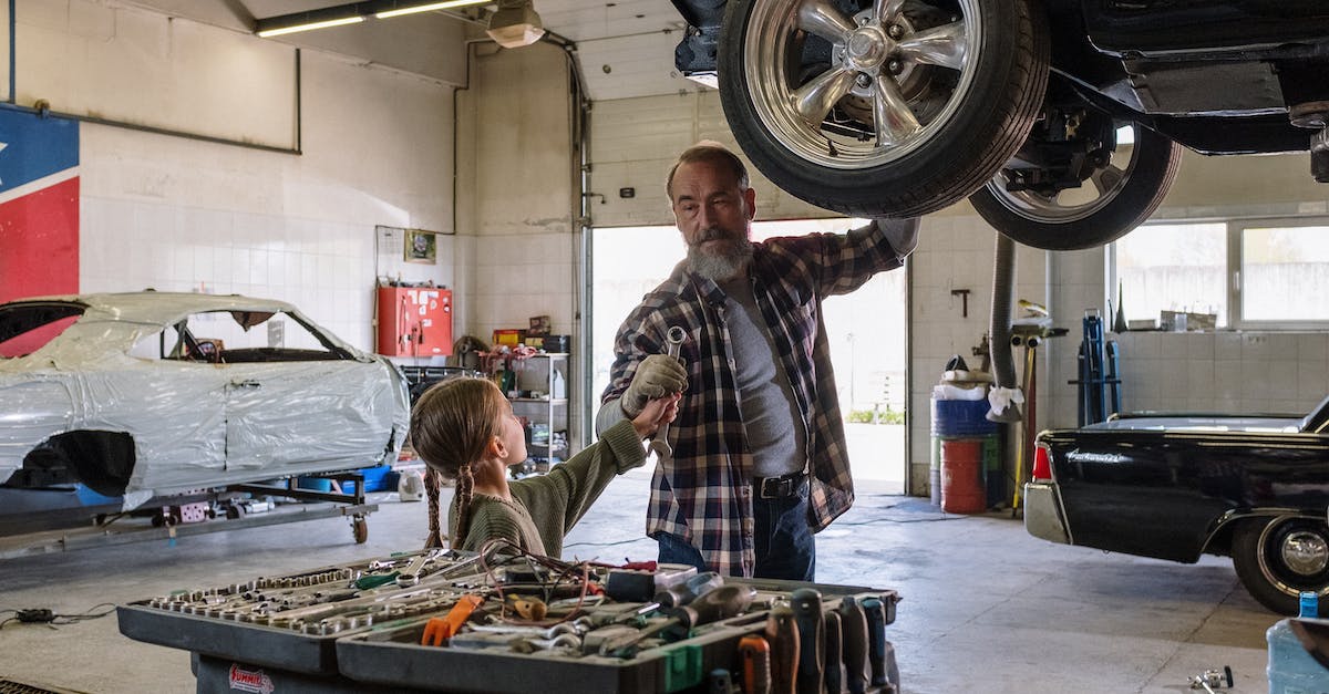 Why wasn't my car saved in Trevor's garage? - Man in Brown and White Plaid Dress Shirt Standing Beside Black and Gray Industrial Machine