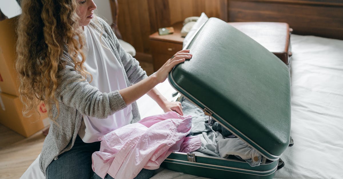 Why won't Amanita move in and settle down? - Focus woman packing suitcase on bed