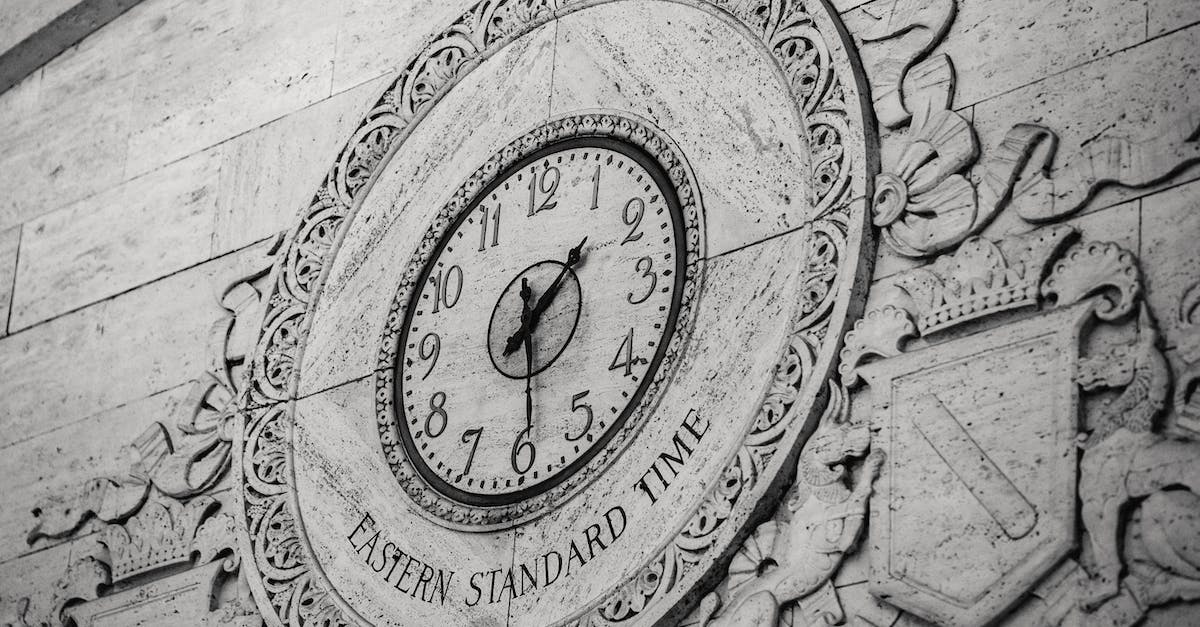 Why won't the time show at the Island? - From below black and white of stone wall with ornamental details around clock showing Eastern Standard Time