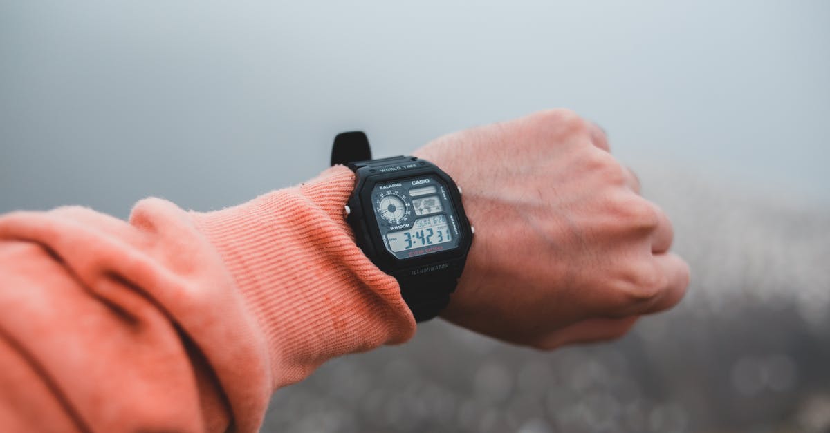 Why won't the time show at the Island? - Crop unrecognizable male demonstrating contemporary wristwatch with time on display in mist on blurred background