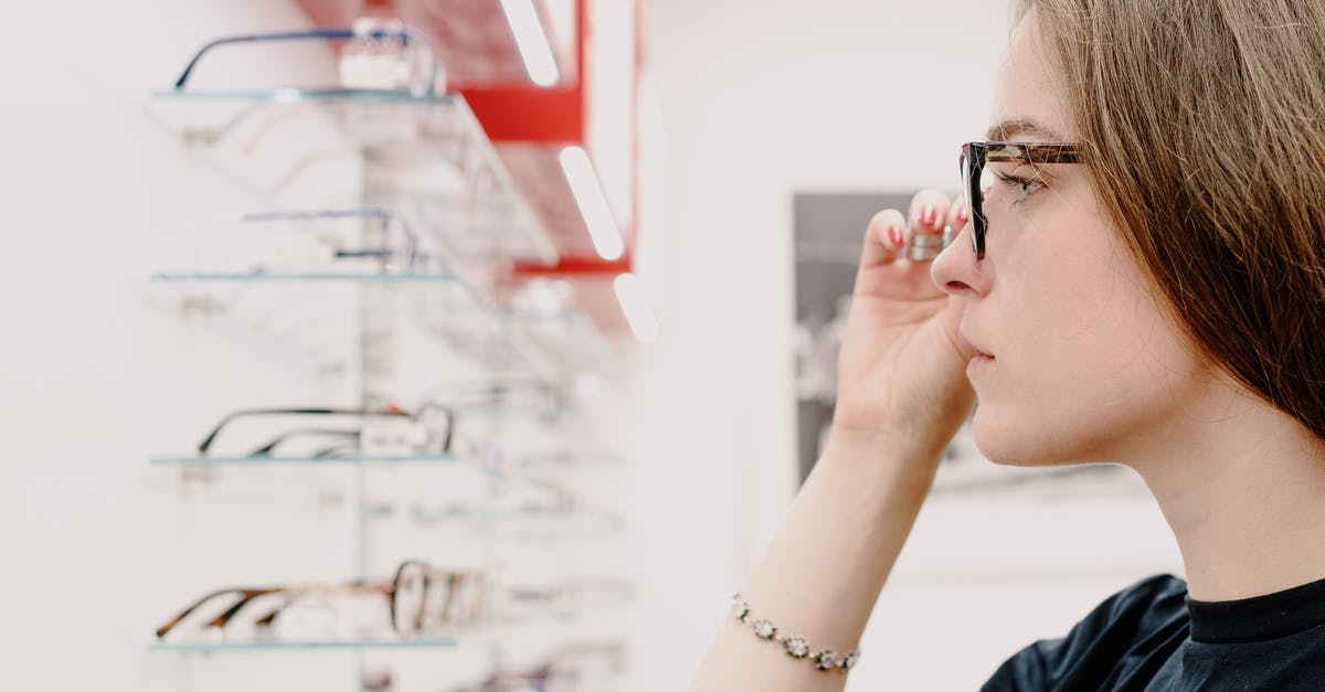 Why would I not choose the Team Offer with the highest bonus? - Side view of crop concentrated female customer putting on eyeglasses for improving eyesight while choosing rim in shop