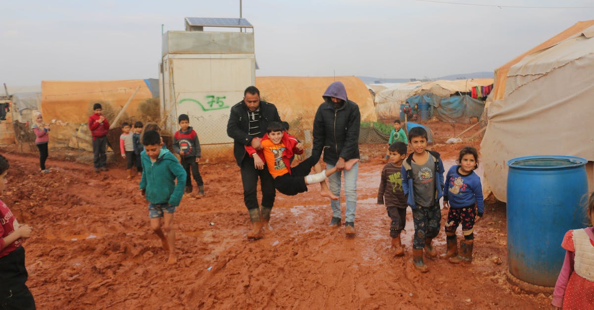 WIll a hero with damage over time die if he is banished? - Ethnic kids and adults walking on dirty road