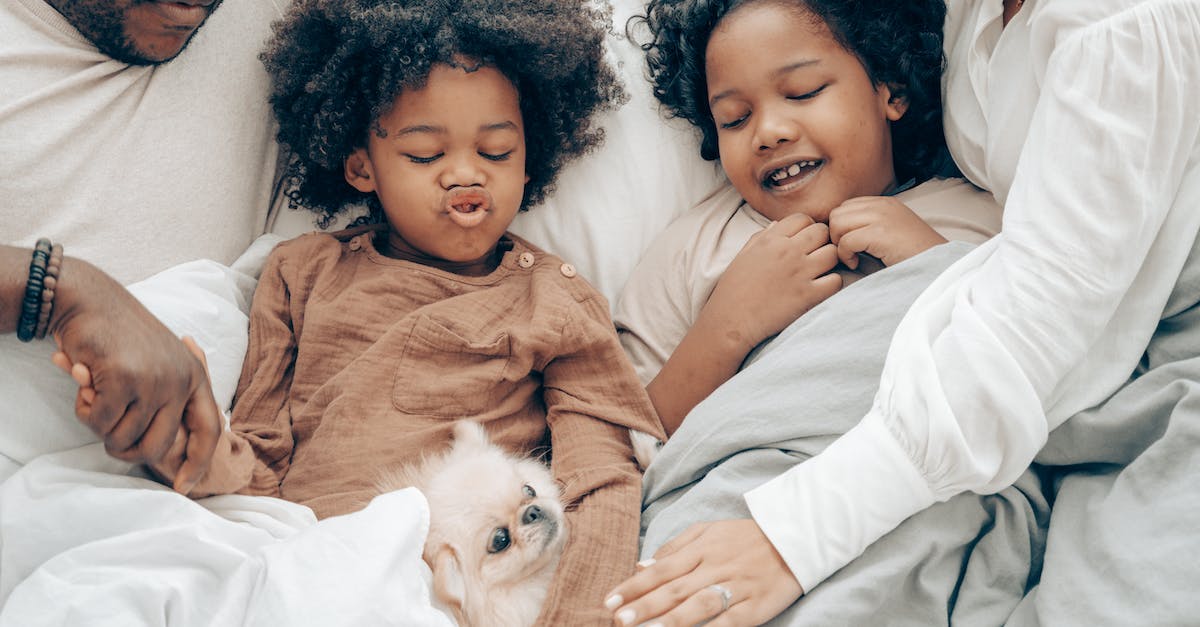 Will a little sister leave you if you kill a big daddy? - Happy ethnic family resting in bed with little dog Will a little sister leave you if you kill a big daddy? - Happy ethnic family resting in bed with little dog