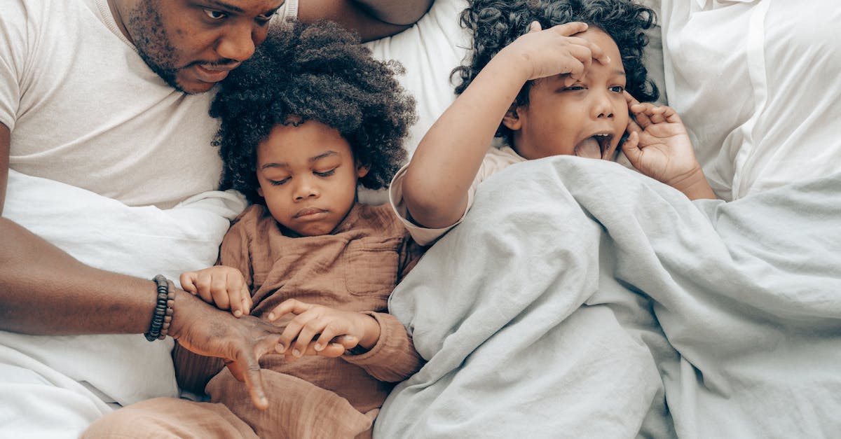 Will a little sister leave you if you kill a big daddy? - Happy black parents with daughters resting on bed Will a little sister leave you if you kill a big daddy? - Happy black parents with daughters resting on bed