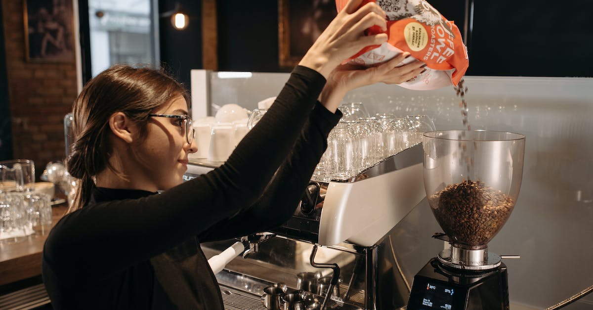 Will bombing the donation machine re-lock already unlocked items? - A Woman in Black Long Sleeves Pouring Coffee Beans in a Grinder