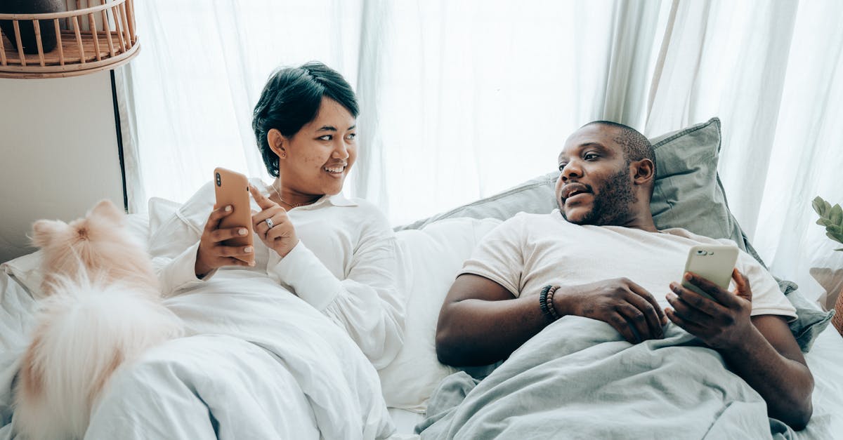 Will game-sharing on xbox one also share content from a deluxe digital edition? - Positive young multiethnic spouses communicating while lying in bed