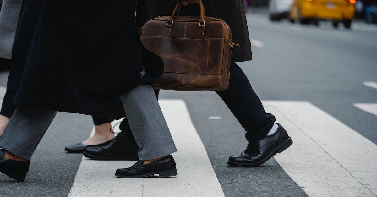 Will Group Finisher Adrenaline Rush impede my other one? - Side view of crop unrecognizable coworkers in formal wear with leather briefcase crossing urban road