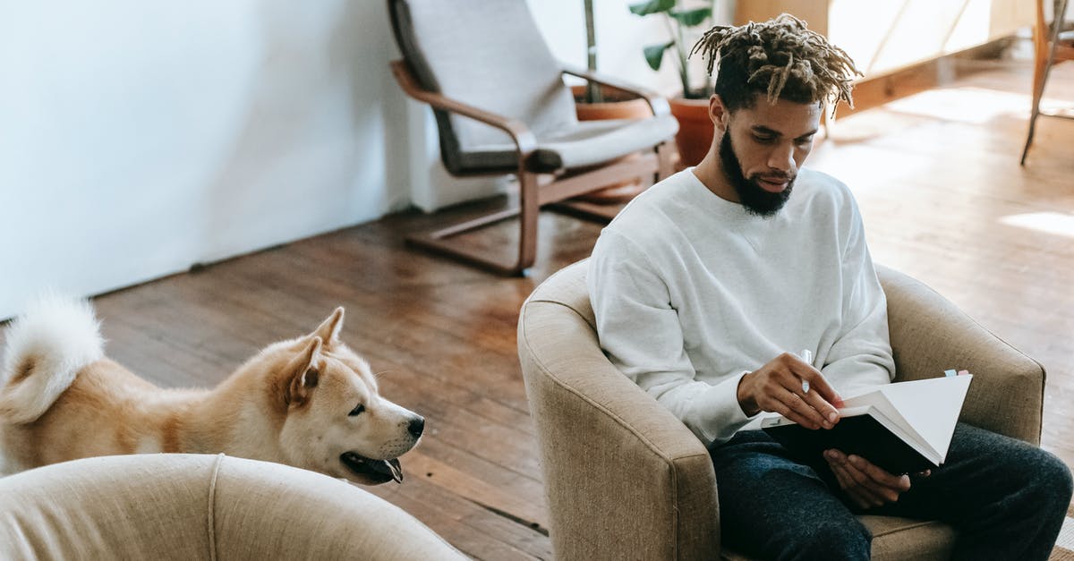 Will I benefit from taking animal beds in a caravan? - Black man with notebook near dog