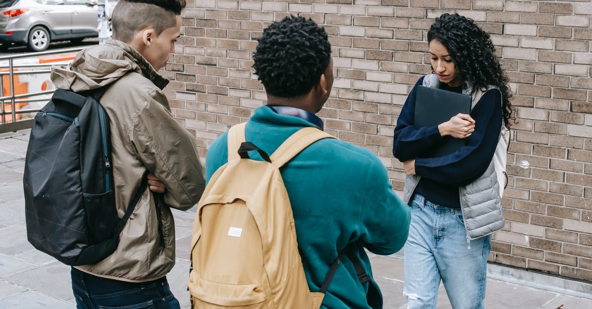 Will I have problems because of a harassment warning? - Young multiracial male friends with backpacks offending female with folder on city street near brick wall in daylight Will I have problems because of a harassment warning? - Young multiracial male friends with backpacks offending female with folder on city street near brick wall in daylight