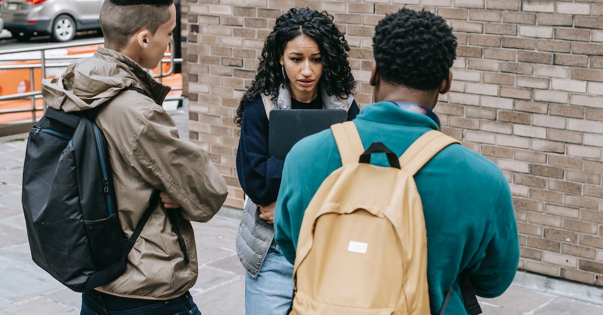Will I have problems because of a harassment warning? - Back view of diverse guys with backpacks bullying and threatening to young scared female groupmate in backyard Will I have problems because of a harassment warning? - Back view of diverse guys with backpacks bullying and threatening to young scared female groupmate in backyard