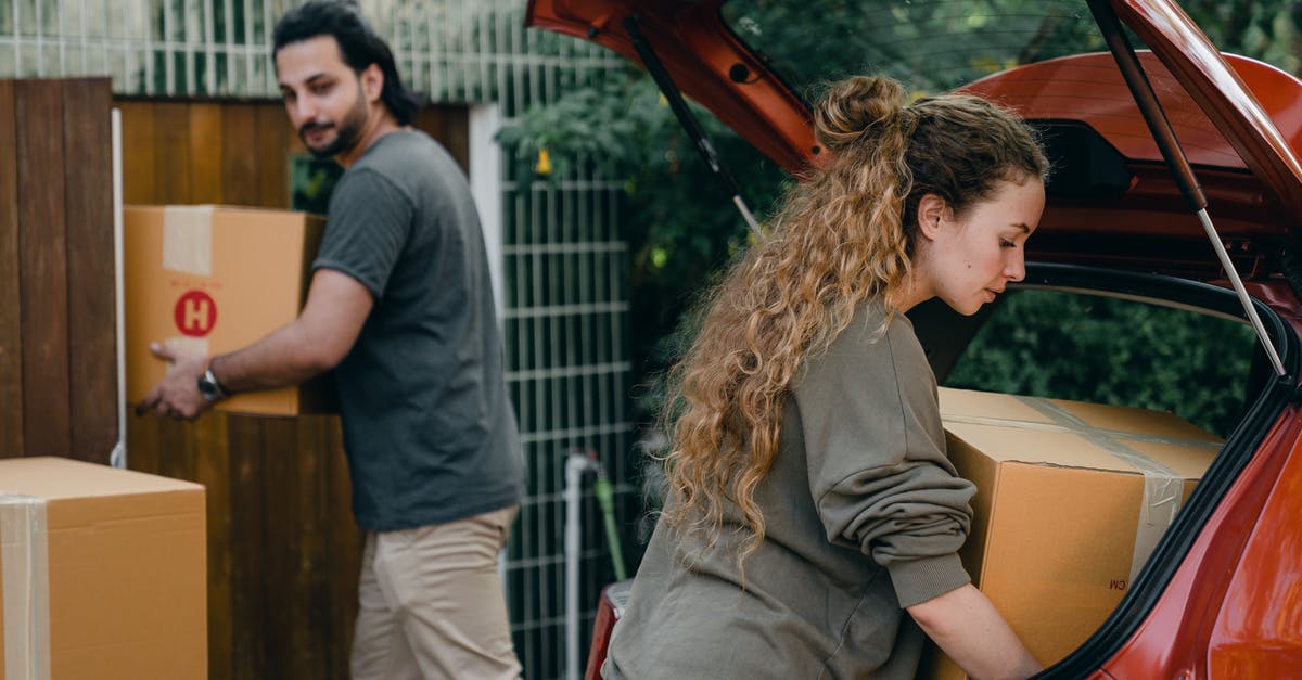 Will I have to buy a new clan? - Young couple unpacking car in yard of new house