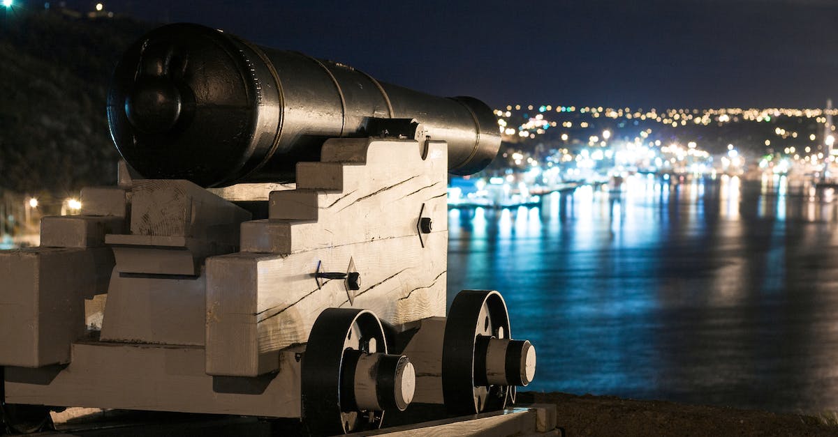 Will My Archer Tower Defend In Clan War During Their Upgradation? [duplicate] - Vintage artillery cannon on wooden support on waterfront of city with glowing lights at night