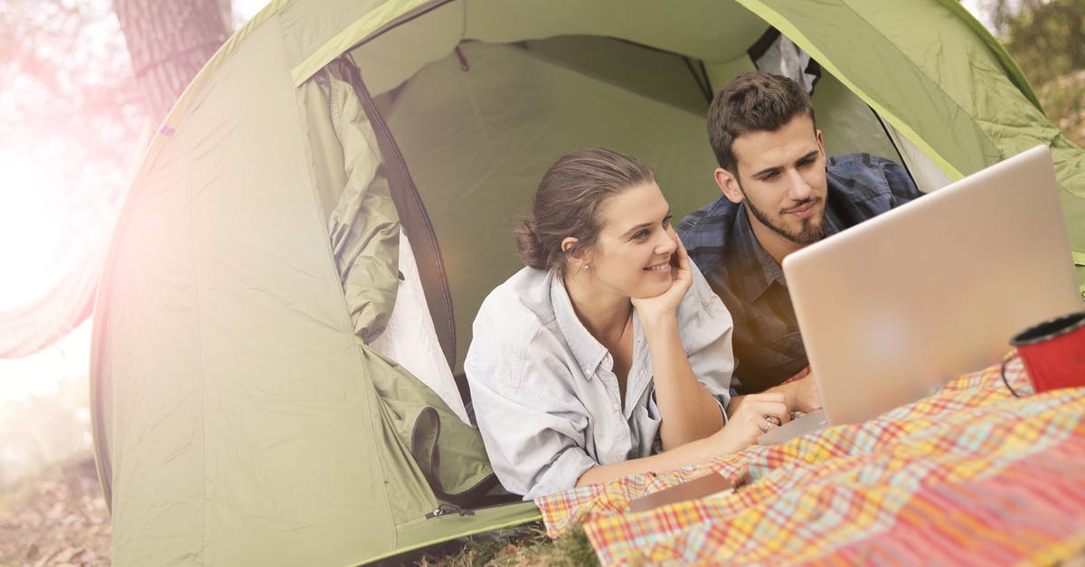 Will my Rust character differ if not using family sharing? - Happy couple using laptop in tent