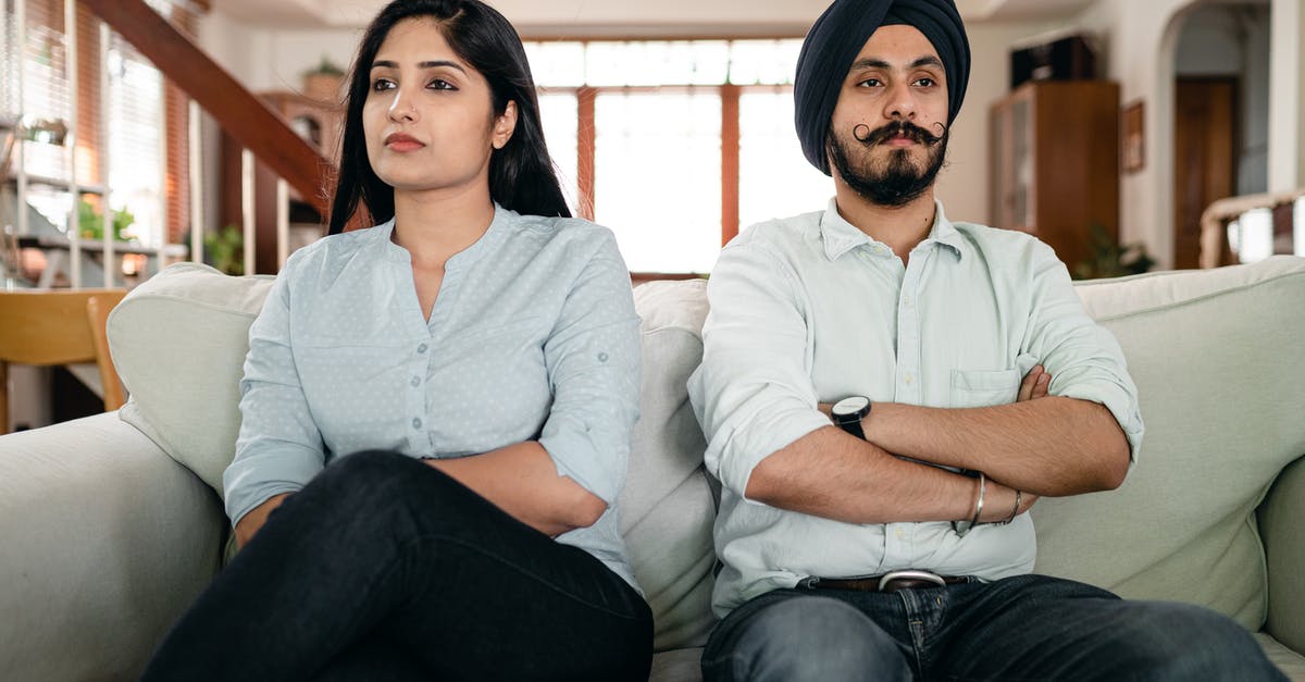 Will my spouse divorce me if I ignore them or pursue others? - Resentful young Indian couple ignoring each other while sitting on couch together with crossed arms