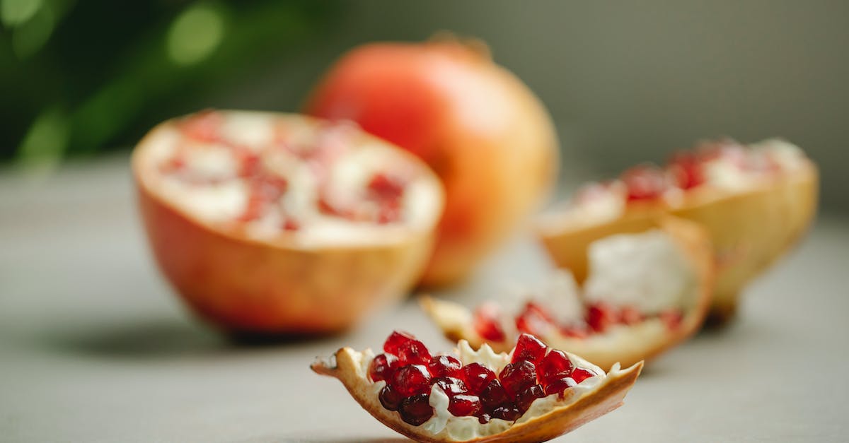Will Other Mobs Spawn in a Slime Chunk - Chunk of ripe pomegranate with red seeds placed on surface near halves of tasty fruit on blurred background in kitchen