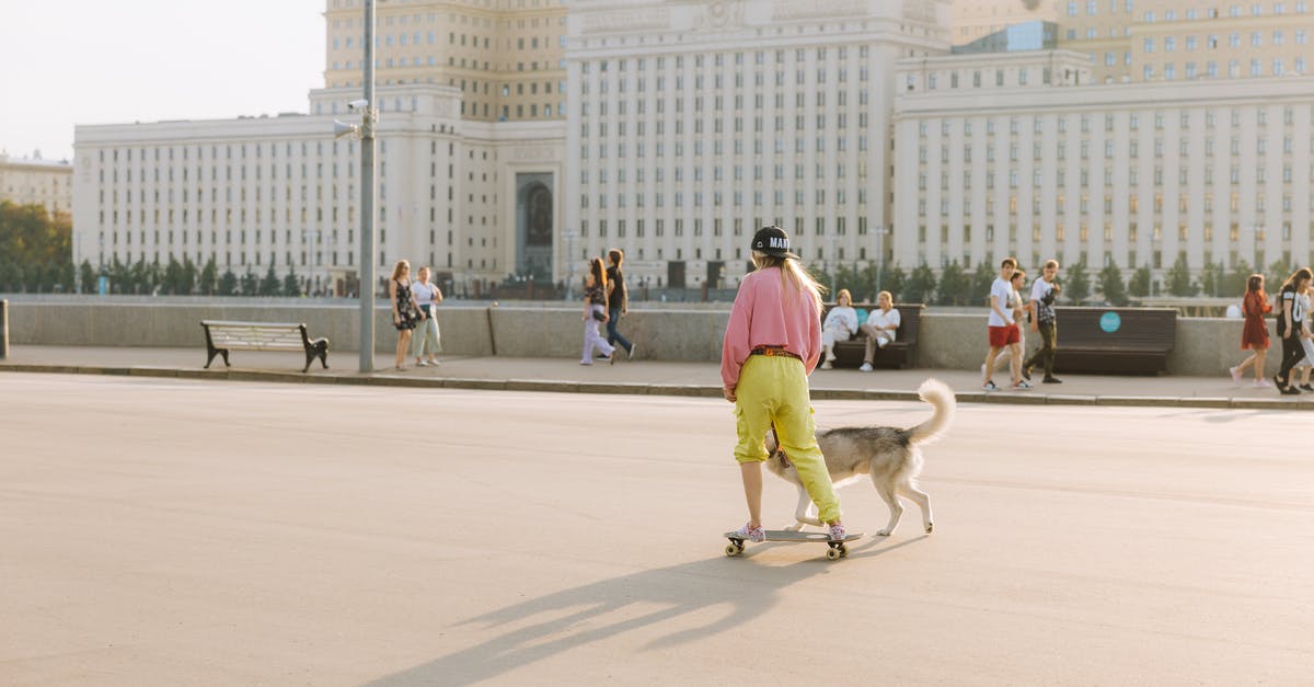 Will riding a rock dog allow me to walk in lava pits? - Woman Riding a Longboard While Walking Her Dog