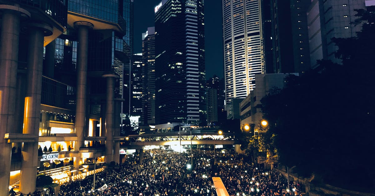 Will Stacked Symmetra's Turrets Stop Genji from Swift Striking Past Them? - From above of crowd of people standing on street in dark modern city centre during mass protest