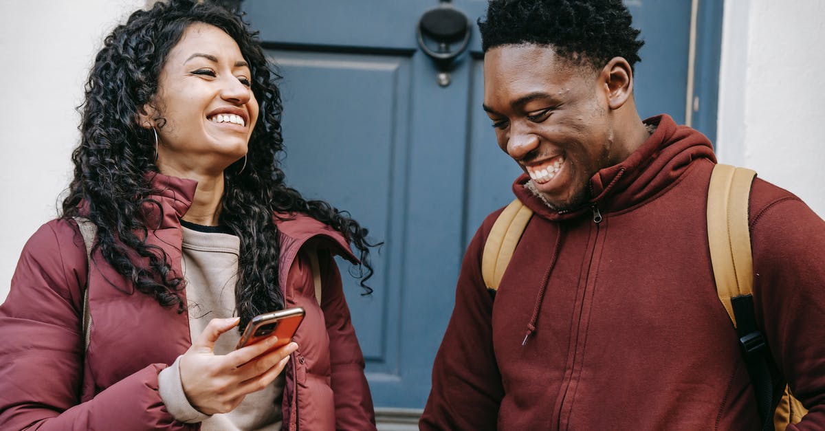 Will Villagers use non-house doors? - Diverse cheerful friends with smartphone laughing near door of building Will Villagers use non-house doors? - Diverse cheerful friends with smartphone laughing near door of building