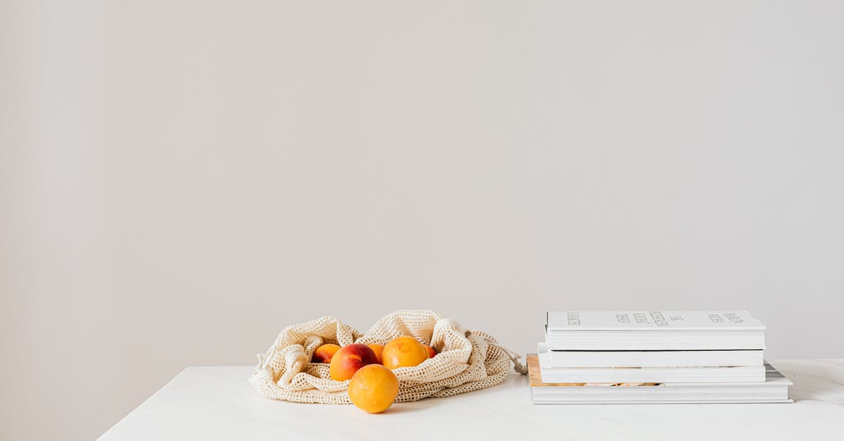 Witcher 3 DPS reducing - Jute sack with natural ripe apricots on white table composed with stack of various books and magazines