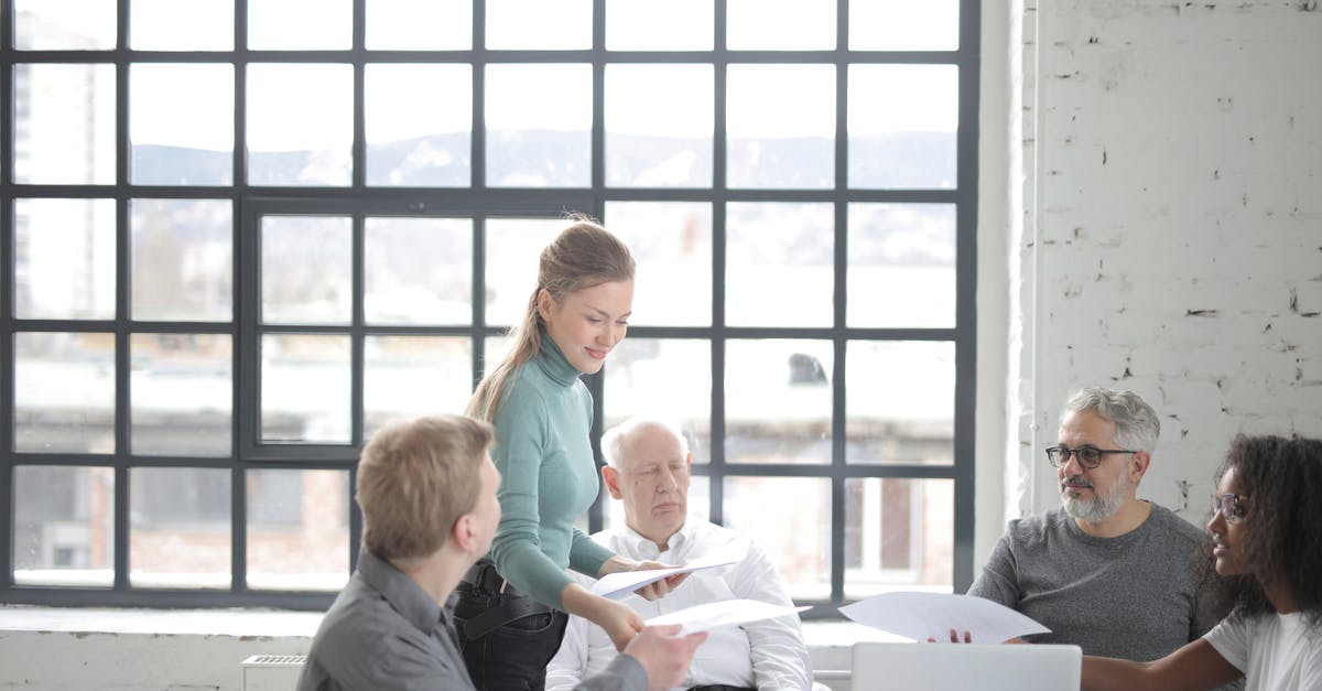 With current team comps will armor usualy be prioritized? - Multiracial coworkers of different ages in casual clothes discussing work plan and current issues at table with laptop in office