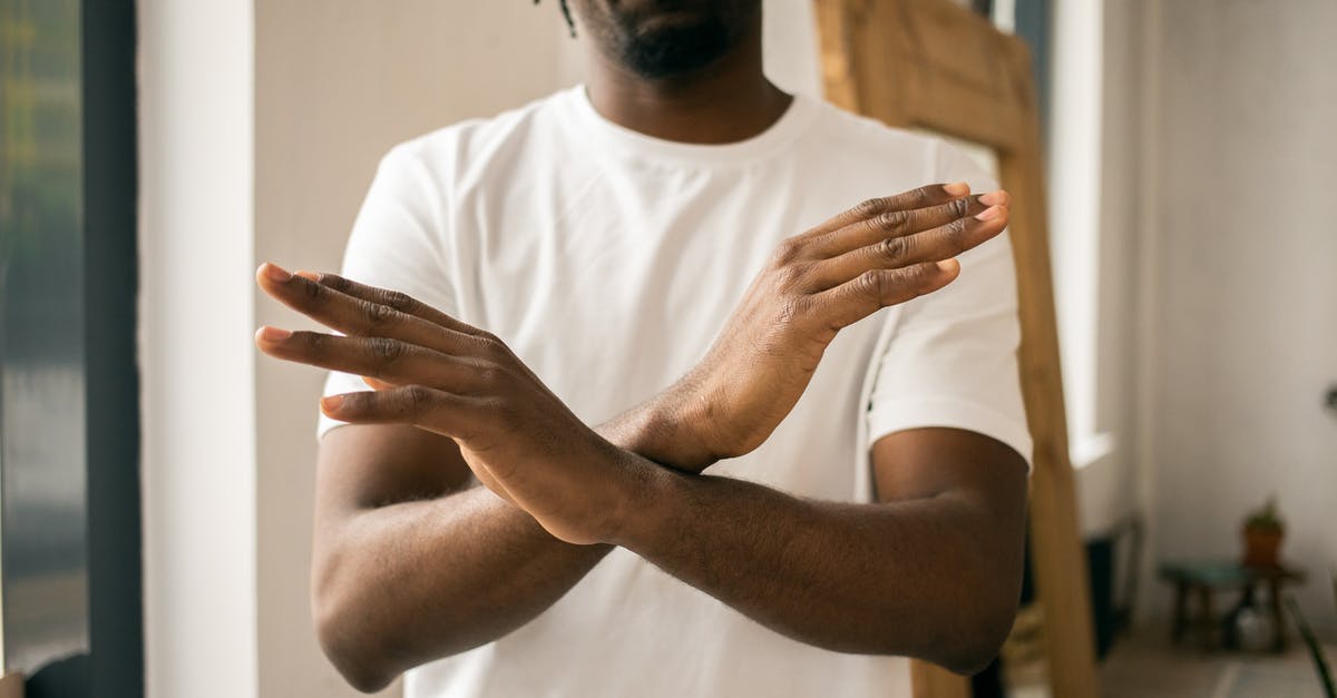 Won't let me sign in with gmail [duplicate] - Crop unrecognizable bearded African American male in white t shirt demonstrating no gesture with hands while standing in light room