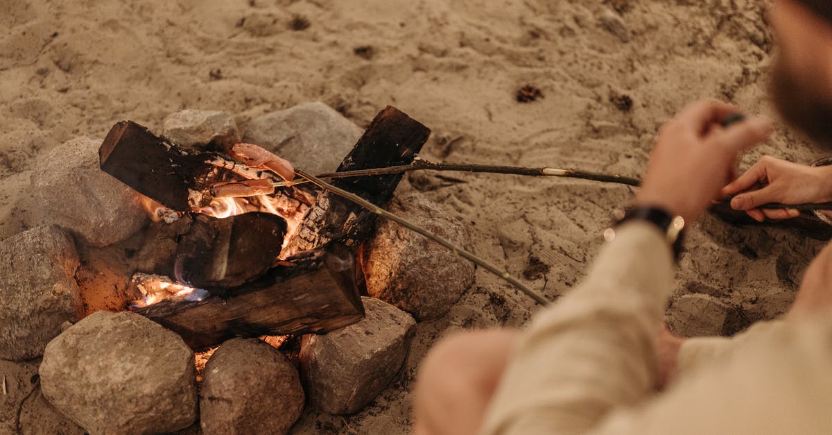 World of Warcraft Campfire Hack - Person in White Pants and Black Socks Holding Black Metal Stick