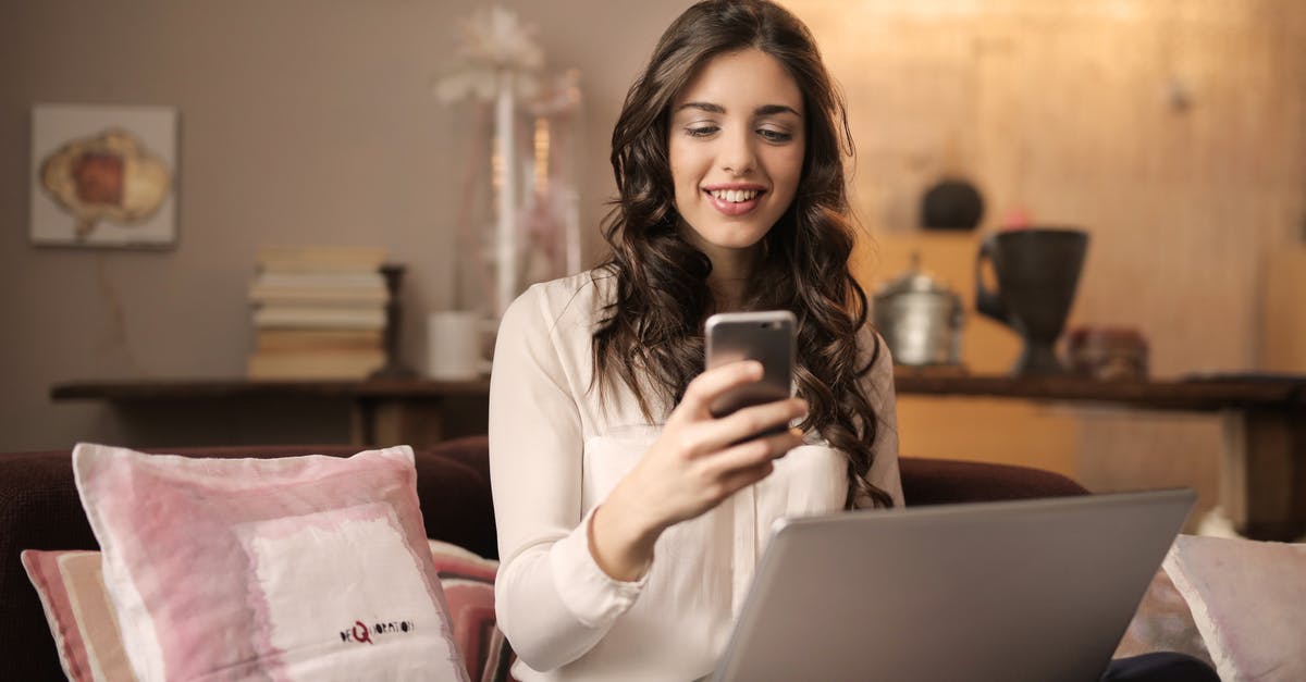 World of Warships mobile to PC - Woman Sitting on Sofa While Looking at Phone With Laptop on Lap World of Warships mobile to PC - Woman Sitting on Sofa While Looking at Phone With Laptop on Lap