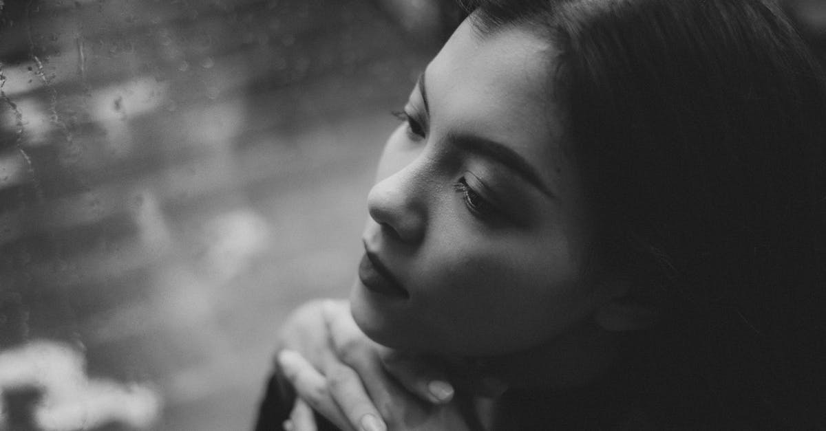 Wrong drop from the reaper? - Black and white high angle of serious teenage girl sitting in solitude near window covered with raindrops Wrong drop from the reaper? - Black and white high angle of serious teenage girl sitting in solitude near window covered with raindrops