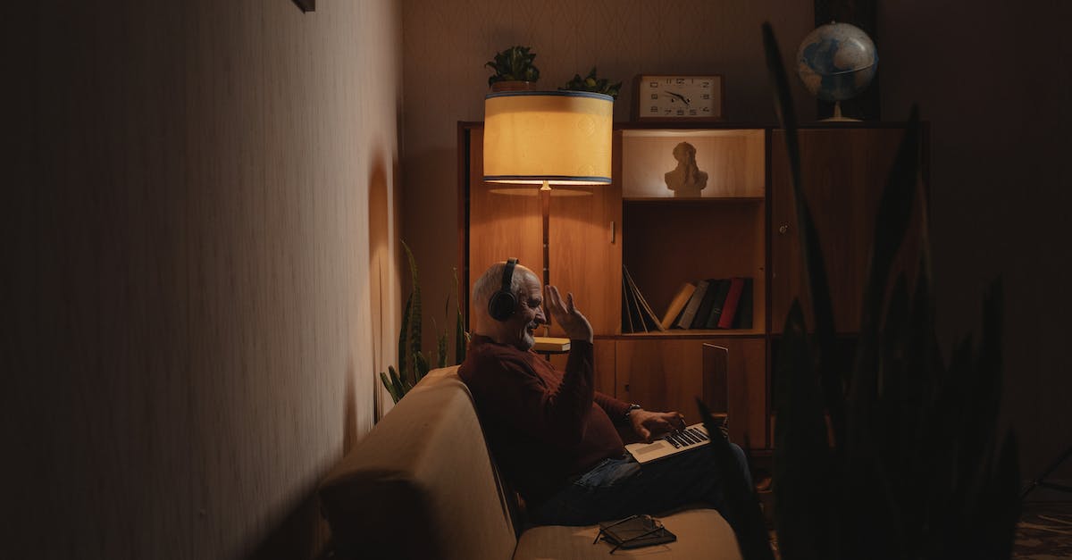 Xbox One + Skype = Echo on other side - An Elderly Man Sitting on the Couch while Using His Laptop Xbox One + Skype = Echo on other side - An Elderly Man Sitting on the Couch while Using His Laptop