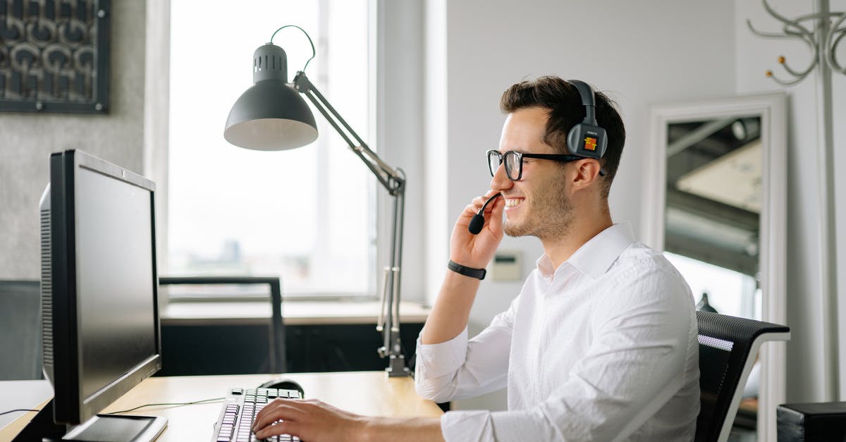 Xbox One included chat headset not working - A Smiling Man Wearing a Headset Looking at His Computer Screen