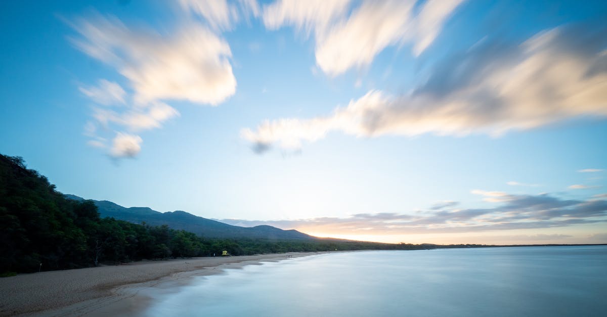 Zeroing the Long Range Scope with multiple zoom levels - Aerial of picturesque scenery of calm sea and shoreline with green forest and cloudy sky with long exposure